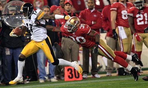 Mike Wallace  es alcanzado por Reggie Smith. FOTO: AP