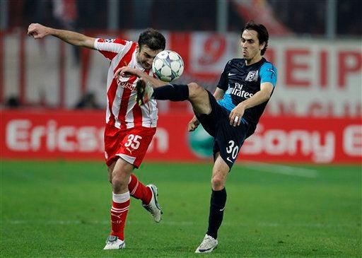 Vassilis Torosisdis del Olympiacos pelea por el esférico. FOTO: AP