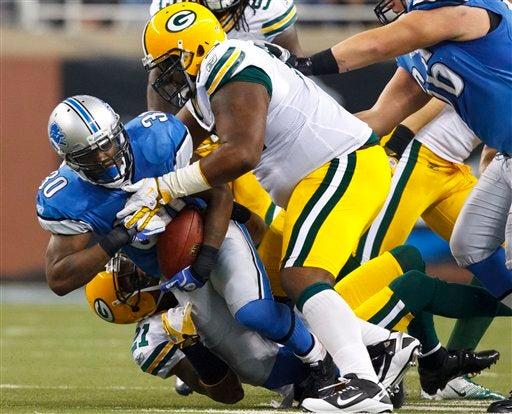 Kevin Smith es tacleado por Green Bay. FOTO: AP