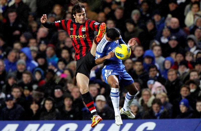 shley Cole salta por el balón junto con David Silva. FOTO: EFE