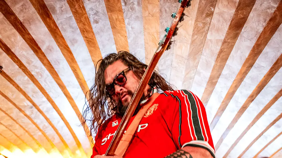 Jason Momoa con la playera del Manchester United tocando el bajo | @brfootball