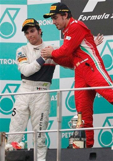 Sergio Pérez saluda a Fernando Alonso, en la pista estuvo a punto de rebasarlo. (FOTO: AP)