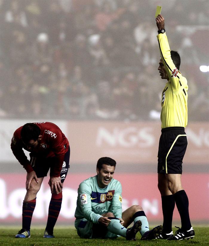 El árbitro muestra la amarilla, Javier Calleja de Osasuna, tras una entrada a Pedro Rodríguez. FOTO: EFE