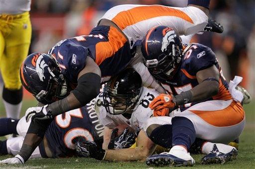 Mark Dell es tacleado por la defensiva de Denver. FOTO: AP