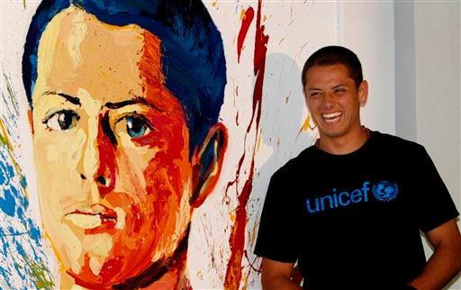 El Chicharito a lado de una pintura durante su nombramiento I AP