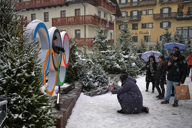 Turistas se toman foto en los aros olímpicos en Cortina d'Ampezzo | AP