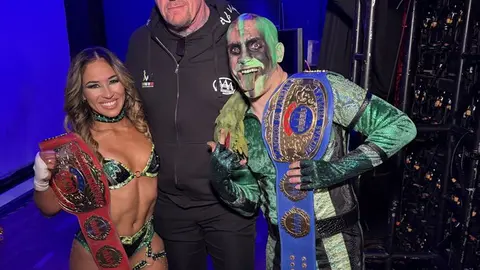 Lola Vice y Mr. Iguana con el Undertaker después de ganar los campeonatos mixtos de AAA | FOTO DE AAA