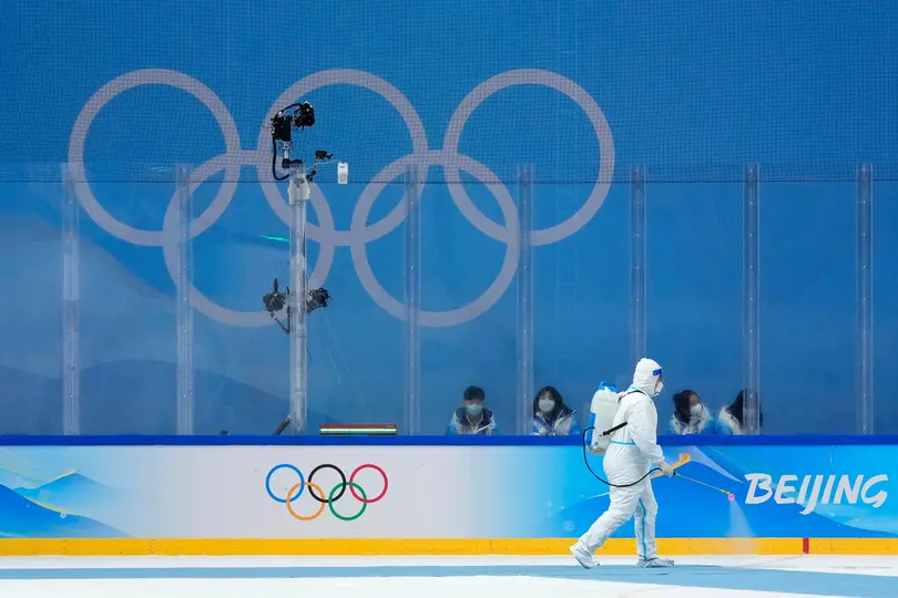 Un trabajador desinfecta una pista de hockey durante los Olímpicos de Invierno de 2022 | AP