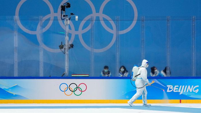 Un trabajador desinfecta una pista de hockey durante los Olímpicos de Invierno de 2022 | AP