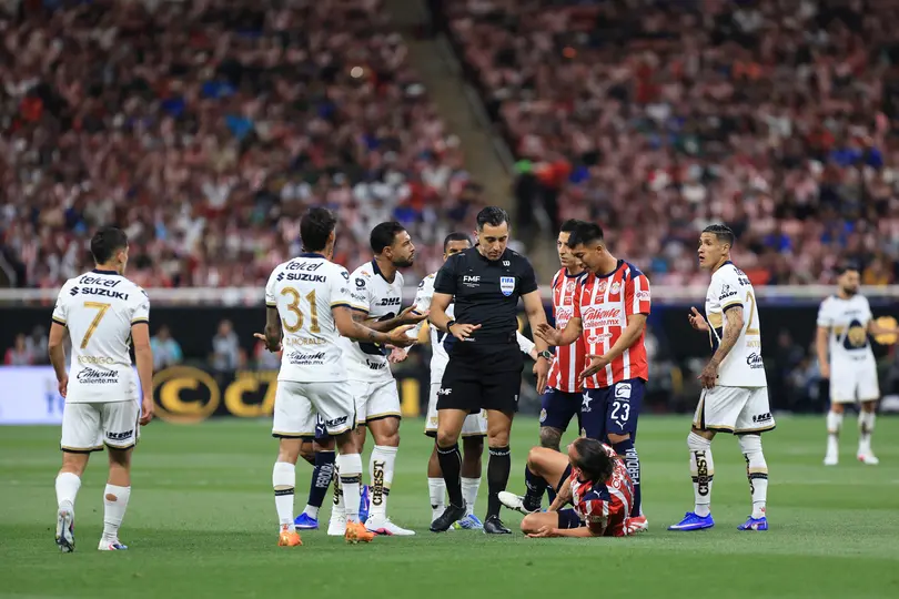 Jugadores de Chivas y Pumas reclaman al árbitro Ismael López en el partido del Clausura 2026 | IMAGO 7