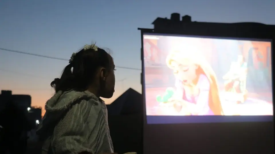 La pantalla fue instalada en un espacio rodeado por las huellas de la guerra, donde decenas de niños pudieron disfrutar de un momento de entretenimiento./ masharawifilms.org