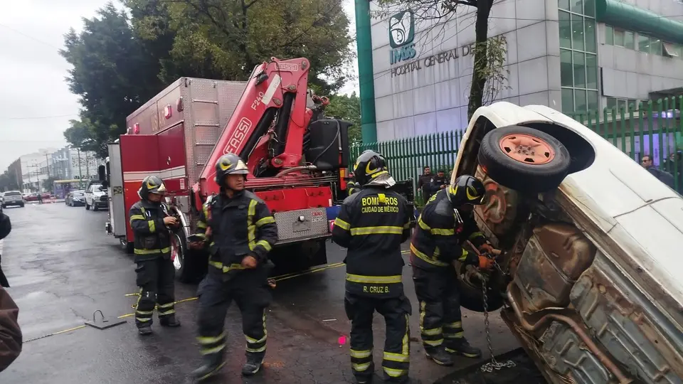 El conductor aseguró que no alcanzó a ver la excavación por la oscuridad y el pavimento mojado./@bomberoscdmx