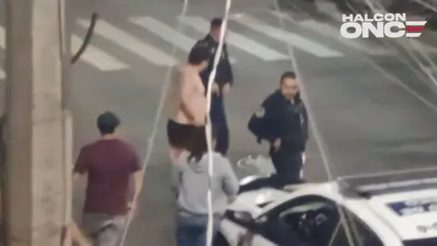 El policía tuvo que sacar su arma para poder dispersar a las personas / Captura de Pantalla