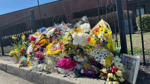 Comunidad escolar lamenta la muerte del profesor dejando flores en la secundaria North Hall. / AP