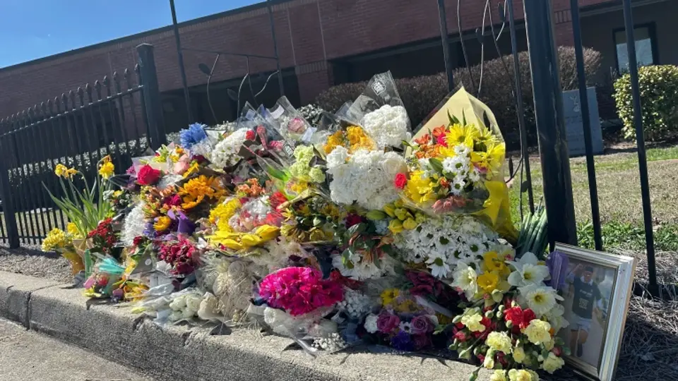Comunidad escolar lamenta la muerte del profesor dejando flores en la secundaria North Hall. / AP