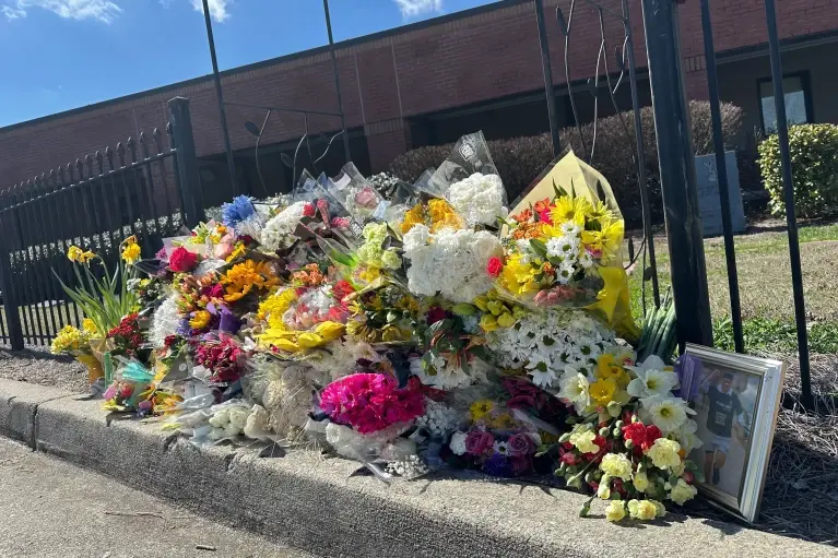 Comunidad escolar lamenta la muerte del profesor dejando flores en la secundaria North Hall. / AP