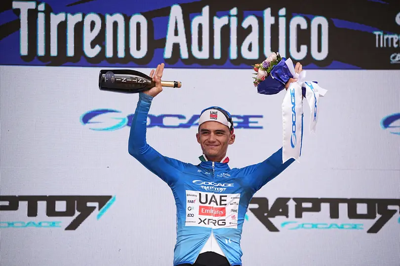 Isaac del Toro en el podio de la Etapa 2 del Tirreno-Adriático 2026, con el jersey azul del líder general | AP