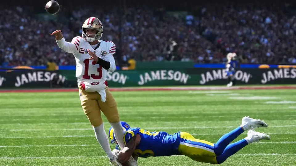 Brock Purdy lanzando un pase con la presión de la defensa de Rams | AP