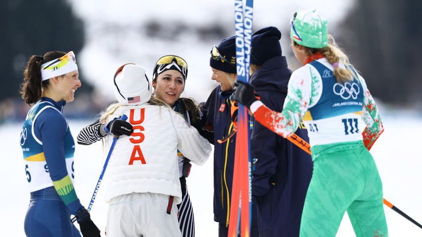 Jessie Diggins y Frida Karlsson, medallistas, felicitan a Regina Martínez una vez que cruzó la línea | AFP