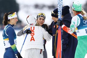 Jessie Diggins y Frida Karlsson, medallistas, felicitan a Regina Martínez una vez que cruzó la línea | AFP