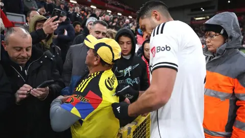 Raúl Jiménez firma playera del América tras caer en Anfield