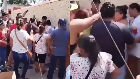 Una mujer con blusa blanca se acerca por detrás del grupo y aparentemente es quien realiza el jalón de cabello. / RS