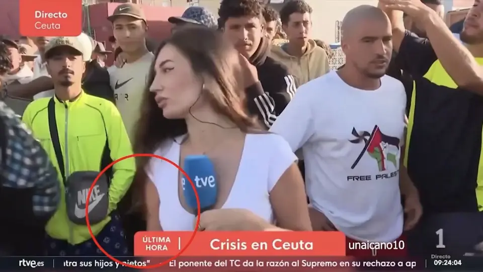El video muestra a la reportera frente a un grupo de hombres durante una transmisión./Captura de pantalla