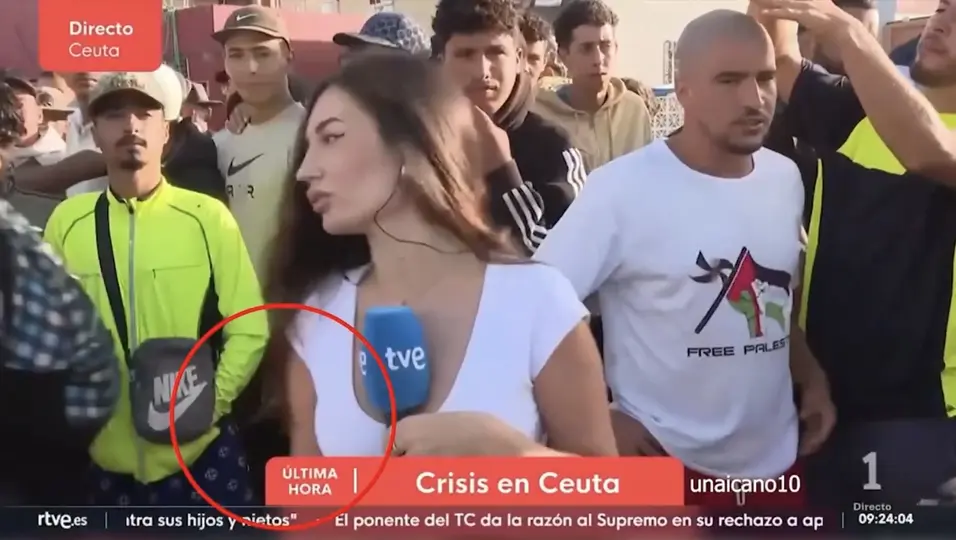 El video muestra a la reportera frente a un grupo de hombres durante una transmisión./Captura de pantalla