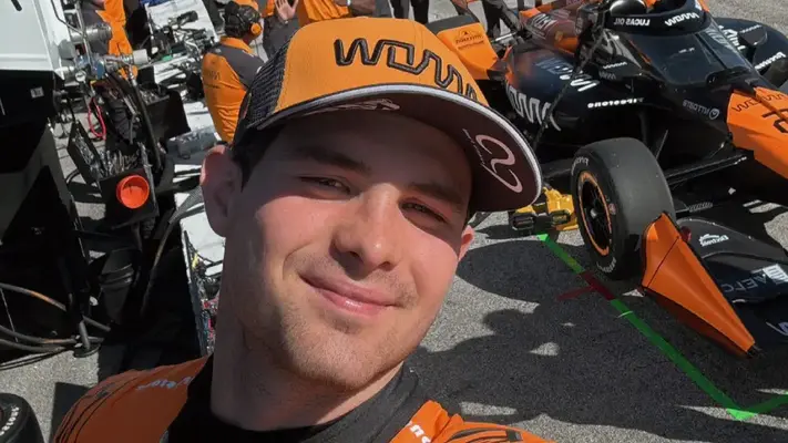 Pato O'Ward firma el pecho de un aficionado que le pidió su autógrafo