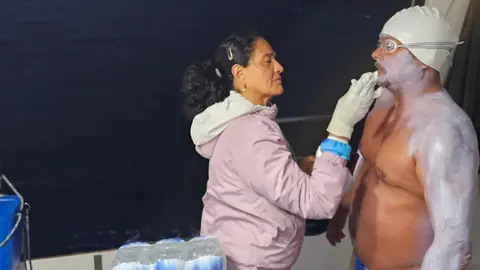 Ezequiel recibiendo bloqueador para evitar problemas con el clima | ESPECIAL
