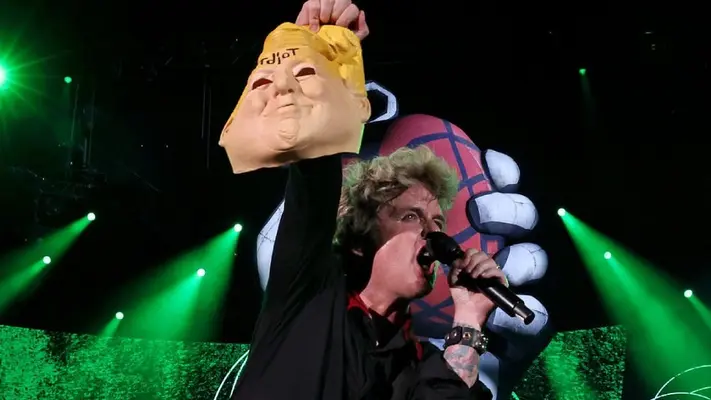 Billie Joe Armstrong, líder de Green Day, es criticado por sostener una máscara de Donald Trump