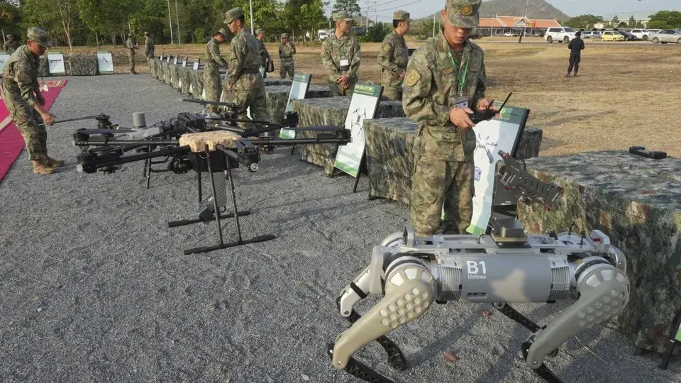 Soldado de China pasea a un perro robot armado con una ametralladora durante ejercicios militares