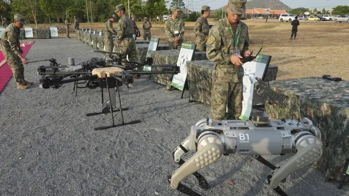 Soldado de China pasea a un perro robot armado con una ametralladora durante ejercicios militares