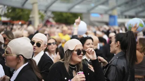 Fans de Pitbull se caracterizan con lentes oscuros y pelucas calvas en sus conciertos. / AP