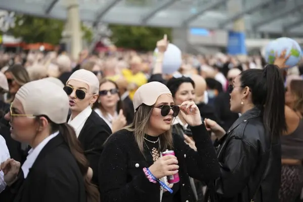 Fans de Pitbull se caracterizan con lentes oscuros y pelucas calvas en sus conciertos. / AP