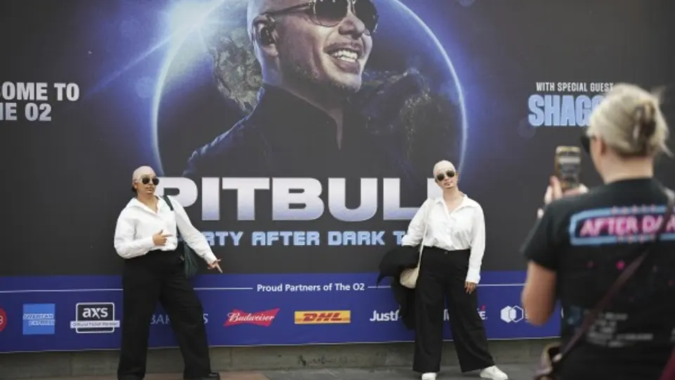Fans posando caracterizadas de Pitbull. / AP