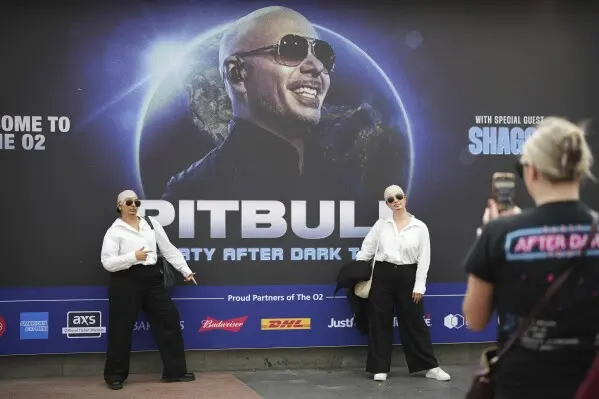 Fans posando caracterizadas de Pitbull. / AP