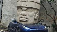 En CDMX aparece Tesla aplastado por una cabeza Olmeca