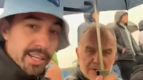 ¡Qué agradable sujeto! Aficionado le ofrece paraguas a Marcelo Bielsa en partido