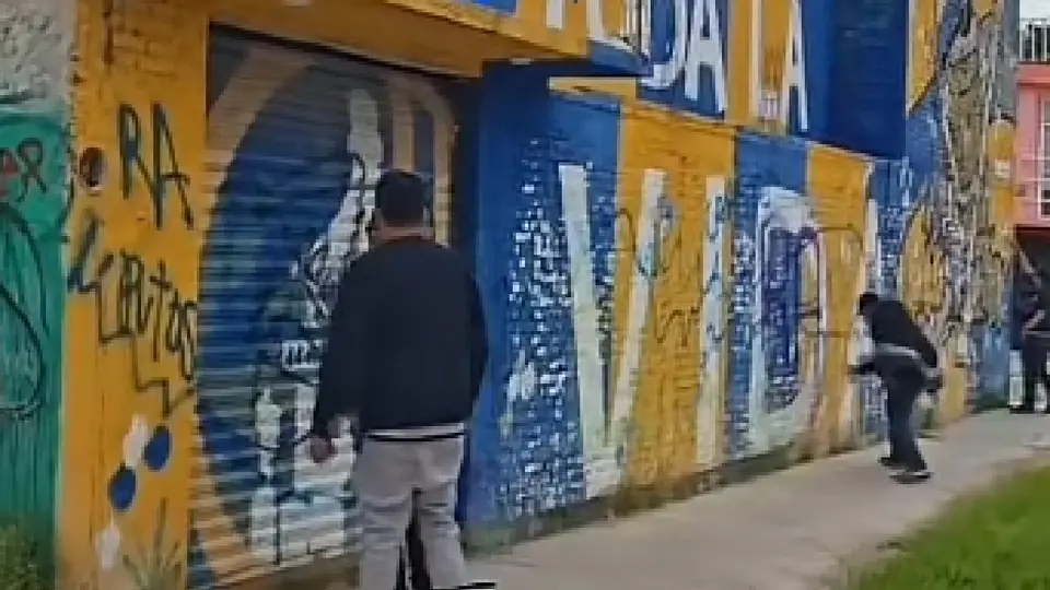 Fanáticos de Gallos pintando una fachada de Atlético de San Luis | CAPTURA