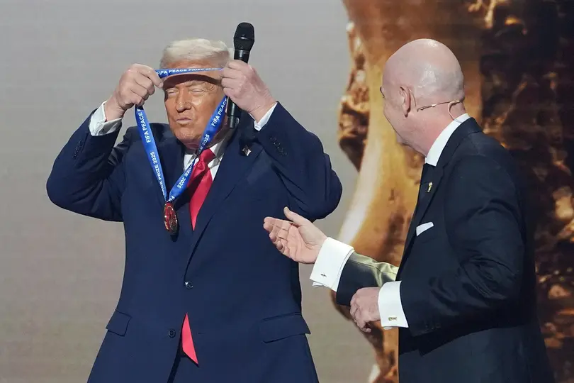 Donald Trump se coloca su medalla del Premio de la Paz de la FIFA junto a Infantino | AP