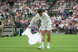 Novak Djokovic utiliza su toalla para secar la cancha en Wimbledon