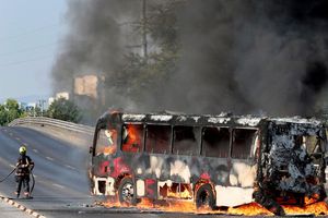 Un bombero extingue las llamas de un camión en Zapopan, durante el operativo en Jalisco | AFP