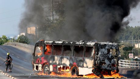 Un bombero extingue las llamas de un camión en Zapopan, durante el operativo en Jalisco | AFP
