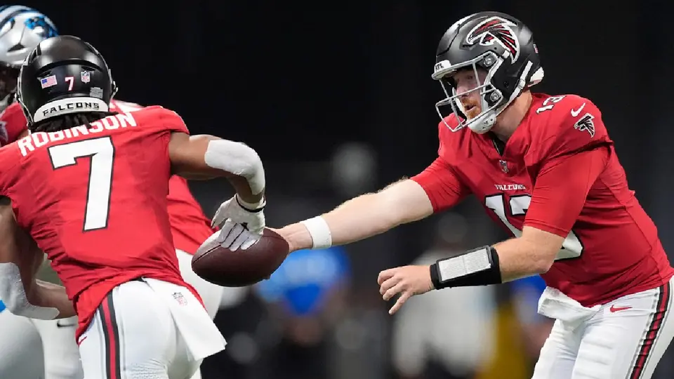 Cooper Rush entregando el balón a Bijan Robinson ante los Panthers | AP