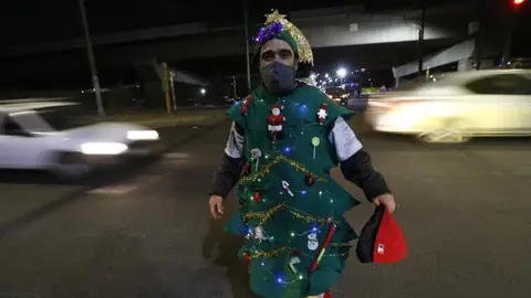 Hombre vestido de árbol de Navidad anima las calles y dirige el tránsito en CDMX