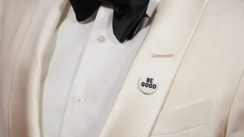 El actor portó unos botones con la frase “BE GOOD” durante la ceremonia de los Golden Globes 2026. / AP