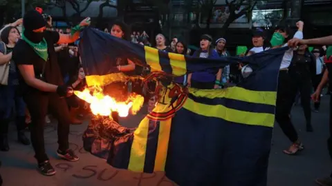 Manifestantes feministas queman bandera del América como protesta