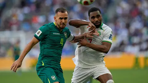 Luis Haquín peleando un balón con jugador de Surinam l AP