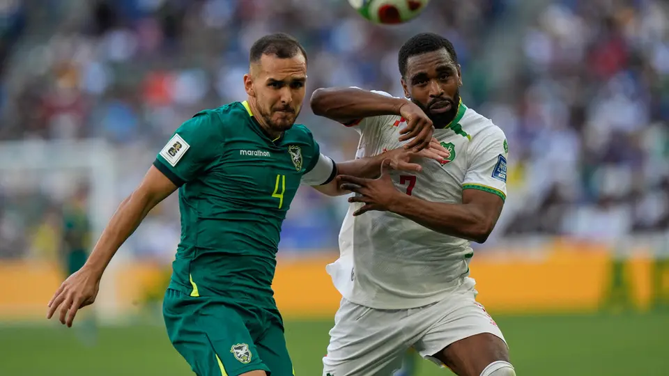 Luis Haquín peleando un balón con jugador de Surinam l AP